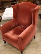 A red dralon upholstered wing armchair