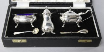 A cased modern plain silver three piece condiment set, with two spoons.