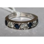 A 18ct white gold seven stone sapphire and diamond half hoop ring, size M.