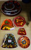 Six Poole Pottery burgundy ground dishes and five red ground dishes (11).