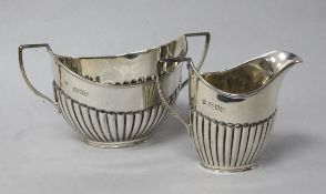 A late Victorian silver demi fluted sugar bowl and a cream jug.