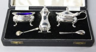 A cased modern silver wavy edged three piece condiment set and two spoons.