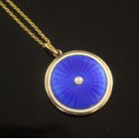 An Edwardian gold, blue guilloche enamel and split pearl circular pendant locket, on a 15ct gold