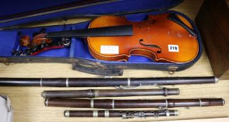 A cased violin and four flutes