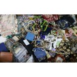 A large quantity of assorted costume jewellery including silver medallions and two lacquer boxes.