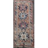 A Derbend apricot ground rug, c.1910, with four geometric motifs in a field of flower heads, 9ft 6in