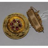 A 19th century gold, garnet and seed pearl set brooch and a gold mourning brooch with plaited hair.