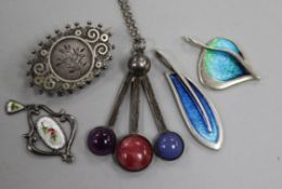 A Charles Horner pendant, two other silver and enamel pendants, a Scottish silver brooch and one