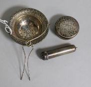 A George V silver tea strainer, a gold mounted cigarette holder with silver case and a silver bottle