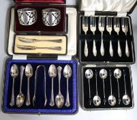 Five cased sets of small silver: a pair of napkin rings, a pair of butter knifes, six coffee bean