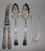 A pair of George III silver berry spoons, a pair of sugar tongs and a pair of American white metal
