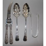 A pair of George III silver berry spoons, a pair of sugar tongs and a pair of American white metal