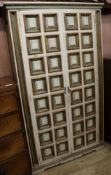 An Italian late 17th century style painted and parcel gilt panelled two door cupboard, H.171cm