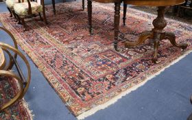 A Persian Heriz red ground carpet, 380 x 280cm, worn