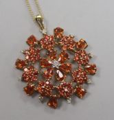 A 9ct gold, orange sapphire? and diamond set pendant, on a 9ct gold fine link chain, pendant 39mm.