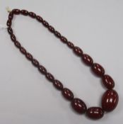 A single strand graduated simulated cherry amber bead necklace, gross 53g, 42cm.