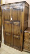 A carved and panelled oak wardrobe, W.96cm