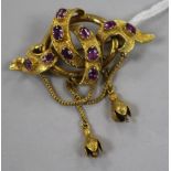 A Victorian textured high carat gold and amethyst or garnet scrolling drop brooch, 4cm.