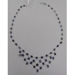 A modern 14ct white gold and sapphire set drop fringe necklace, 38cm.