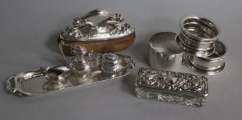 Three single napkin rings, a miniature three piece silver tea set and a tray, an American nail