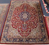 A Tabriz red ground silk rug signed 198 x 133cm.