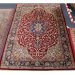 A Tabriz red ground silk rug signed 198 x 133cm.