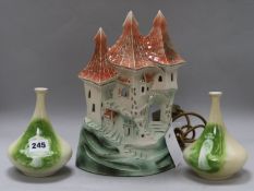 A castle-shaped pottery lamp and a pair of vases