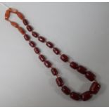 A single strand simulated cherry amber bead and five agate bead necklace, gross 112 grams, 62cm.
