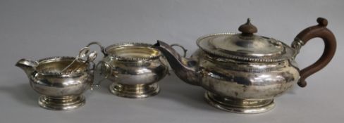 A George V silver three piece tea set by William Neale Ltd, Birmingham, 1926, and a pair of plated