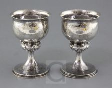 A pair of George V Arts & Crafts planished silver goblets, by Omar Ramsden & Alwyn Carr, with