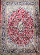 An Isfahan red and ivory ground carpet, with central medallion in a field of scrolling foliage and