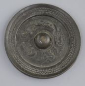 A small Chinese bronze circular mirror, Tang dynasty, 7th-9th century A.D., cast in relief with