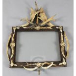 A Black Forest stag horn and antler mounted picture frame, height 29in. width 22in.