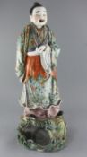 A large Chinese famille rose figure holding a flute, late 19th century, wearing a brocade pattern