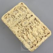 A Chinese export ivory card case, 19th century, carved in high relief and openwork with figures amid