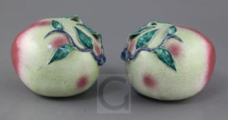 A pair of Chinese enamelled porcelain models of peaches, 19th century, applied with leaf sprigs,