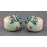 A pair of Chinese enamelled porcelain models of peaches, 19th century, applied with leaf sprigs,