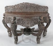 A 19th century Burmese carved hardwood console table, of demi-lune form, carved and pierced with