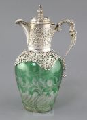 A late Victorian pierced repousse silver mounted green and clear cut glass claret jug by William