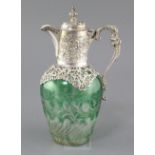 A late Victorian pierced repousse silver mounted green and clear cut glass claret jug by William