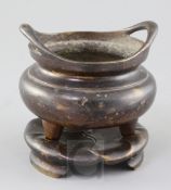 A Chinese bronze ding censer and stand, the censer with a pair of high looped handles, the base with