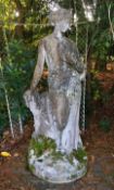 A life size reconstituted stone figure of a classical woman, with one hand resting upon a