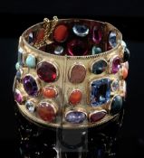 A 20th century Middle Eastern gold and multi gem set tapering articulated bracelet, set with forty