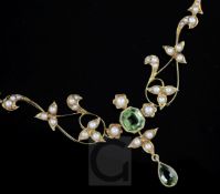 A late Victorian 15ct gold, peridot and seed pearl drop necklace, of scrolling design, 42cm.