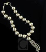 An 18ct gold bead bracelet with tasselled drop, 18cm