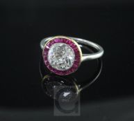 An early 20th century platinum and single stone diamond ring with ruby set yellow gold border, the