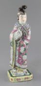 A Chinese famille rose standing figure of a lady, late 19th century, wearing a flower painted pink