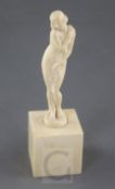 A Joe Descomps carved ivory figure of a standing nude woman holding a floral garland, signed, on