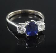 A modern 18ct white gold and three stone diamond and sapphire ring, size J.