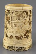 A Chinese ivory brush pot, early 19th century, finely carved in high relief with scholars and